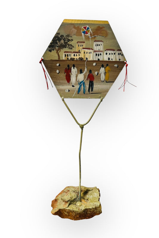 Μεταλλικός χαρταετός ζωγραφισμένος στο χέρι σε βάση από βράχο