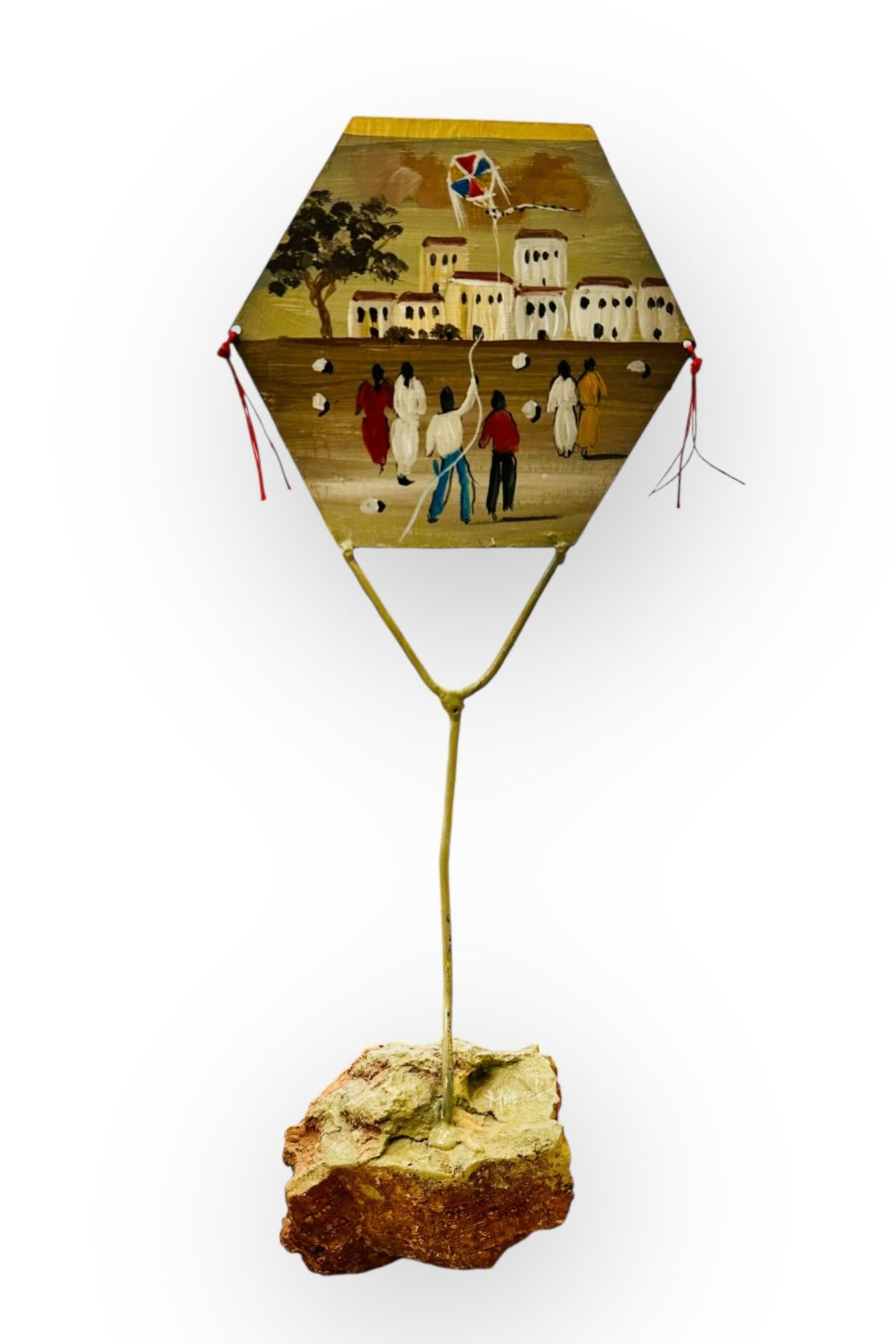 Μεταλλικός χαρταετός ζωγραφισμένος στο χέρι σε βάση από βράχο